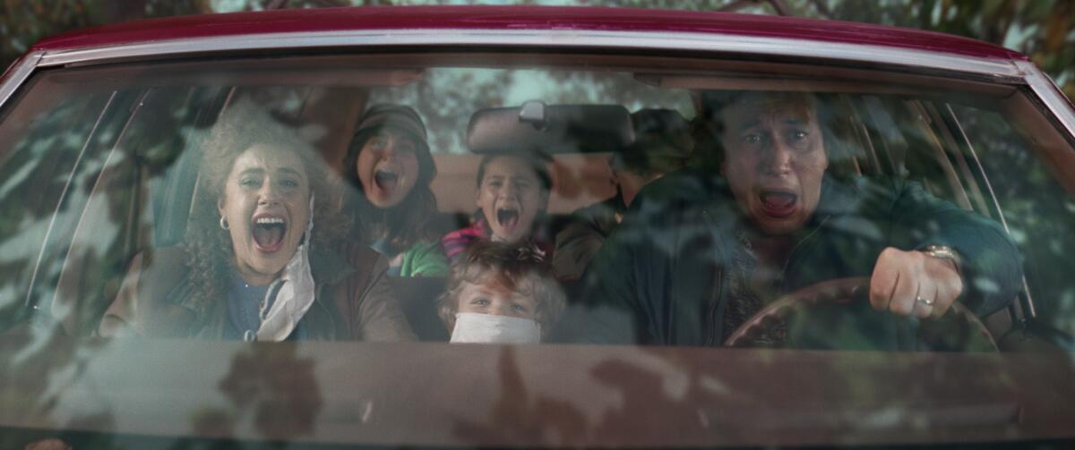 Greta Gerwig and Adam Driver and three kids scream as their car flies into the air.