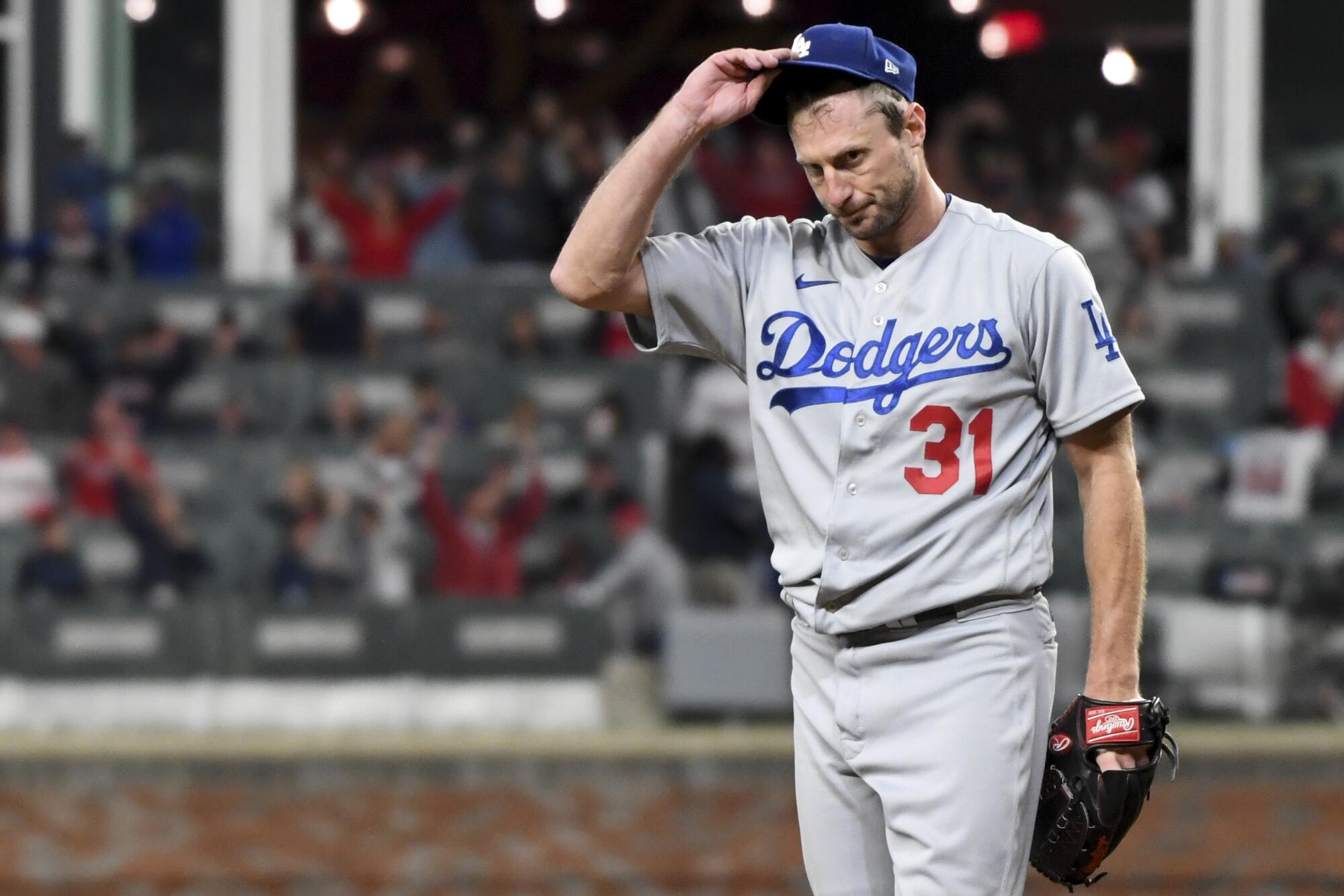 Dodgers starting pitcher Max Scherzer reacts while Braves' Joc Pederson rounds the bases