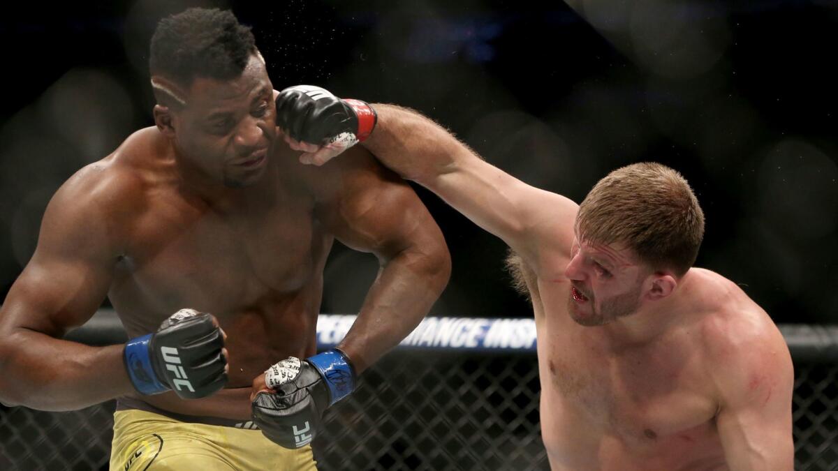 Stipe Miocic lands a right hand against Francis Ngannou during a heavyweight championship mixed martial arts bout at UFC 220.
