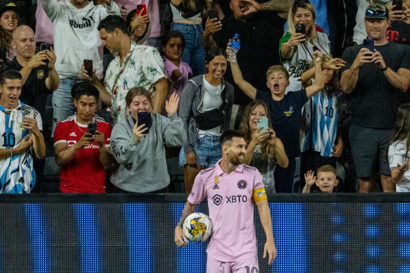 Fans cheer and take pictures as Inter Miami star Lionel Messi smiles and prepares to inbound the ball