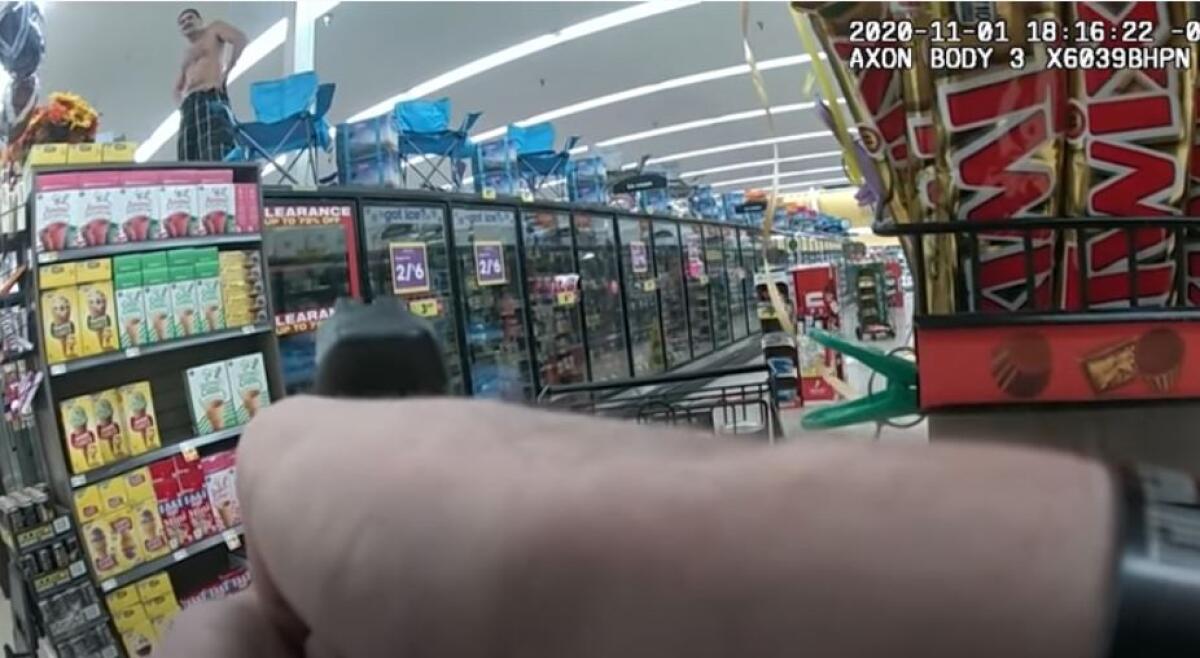 A suspect stands on top of freezers in a supermarket