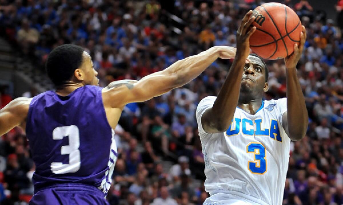 UCLA's Jordan Adams, right, scores on a shot over Stephen F. Austin's Deshaunt Walker during the Bruins' 77-60 win in the third round of the NCAA tournament Sunday. Adams' knack for scoring points or grabbing rebounds at critical junctures of games makes him a valuable asset for UCLA.