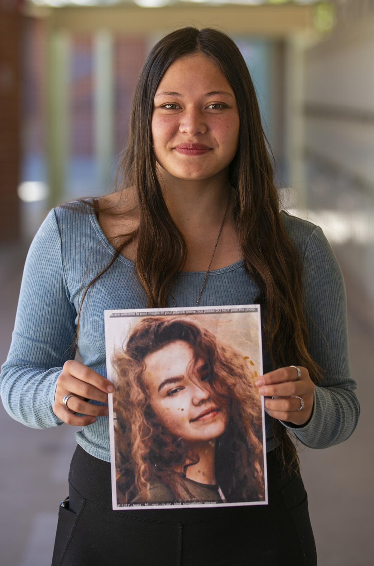 Costa Mesa student Dharma Andreas, 18, with a picture of the student she painted Anna.