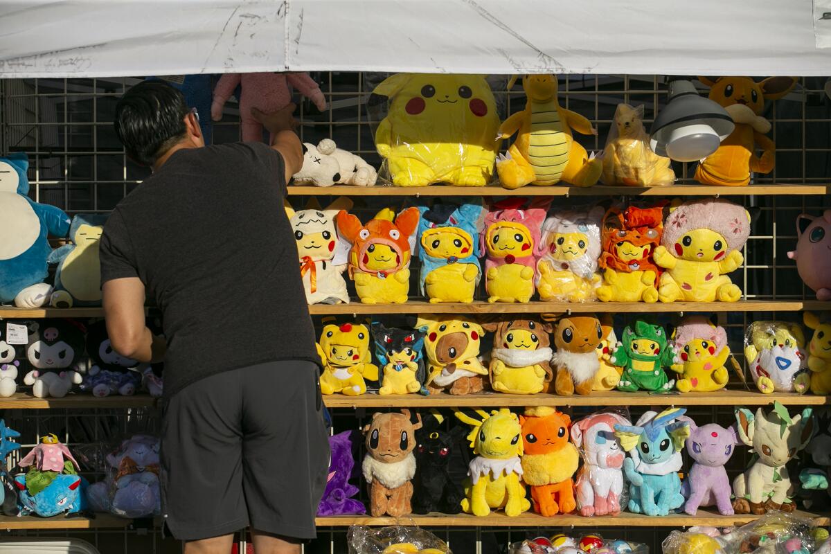 Alex Yao prepares his booth for customers during the opening night of the OC Japan Fair  on Friday.