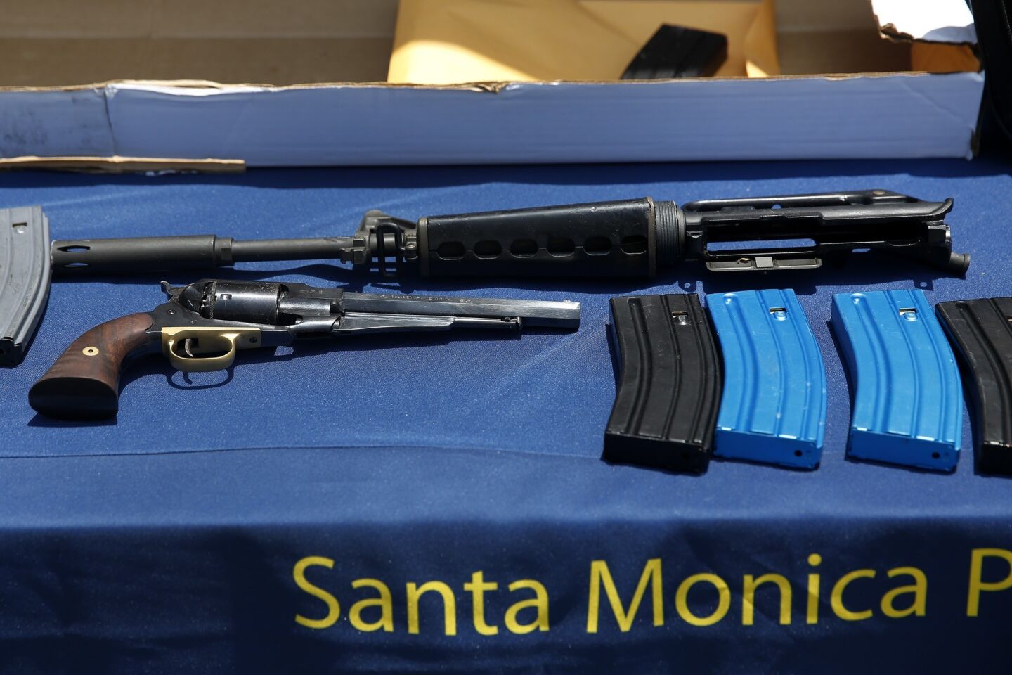 Police display a .44-caliber handgun and parts of an AR-15 style, .223-caliber, semiautomatic rifle, along with multiple clips and boxes of ammunition and knee pads that belonged to the gunman, identified as John Zawahri.