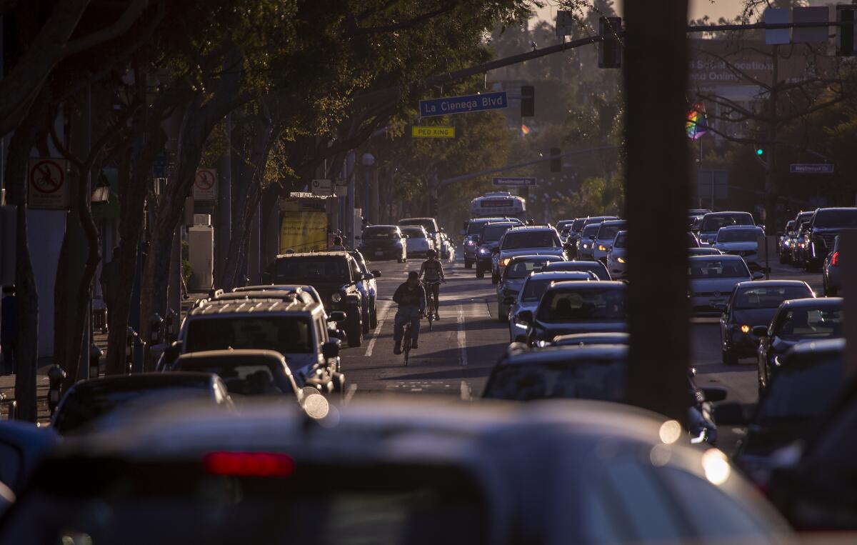 Cyclists ride in a bike lane as traffic stacks up on Santa Monica Boulevard in West Hollywood. 