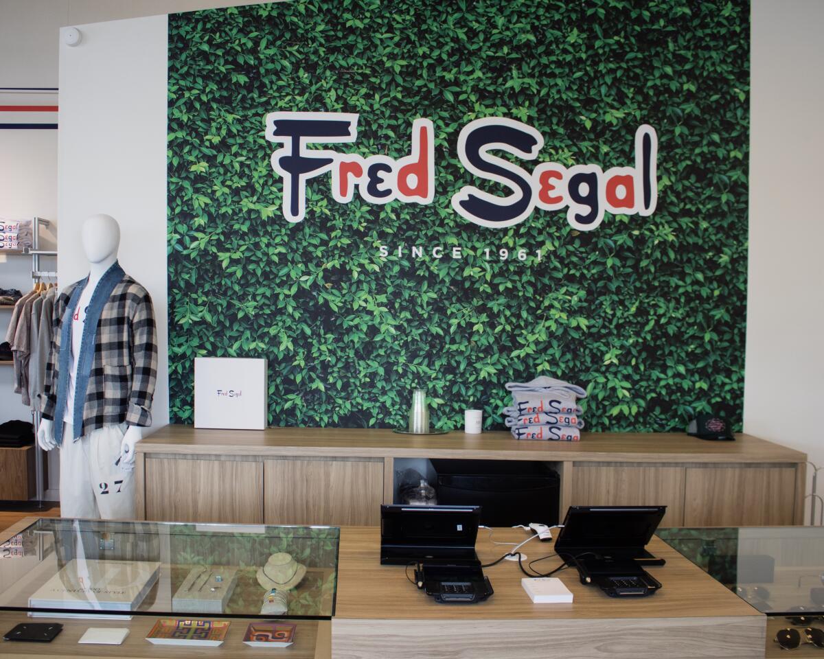 A counter in a clothing store with a mannequin in the background and the name "Fred Segal" on the wall.