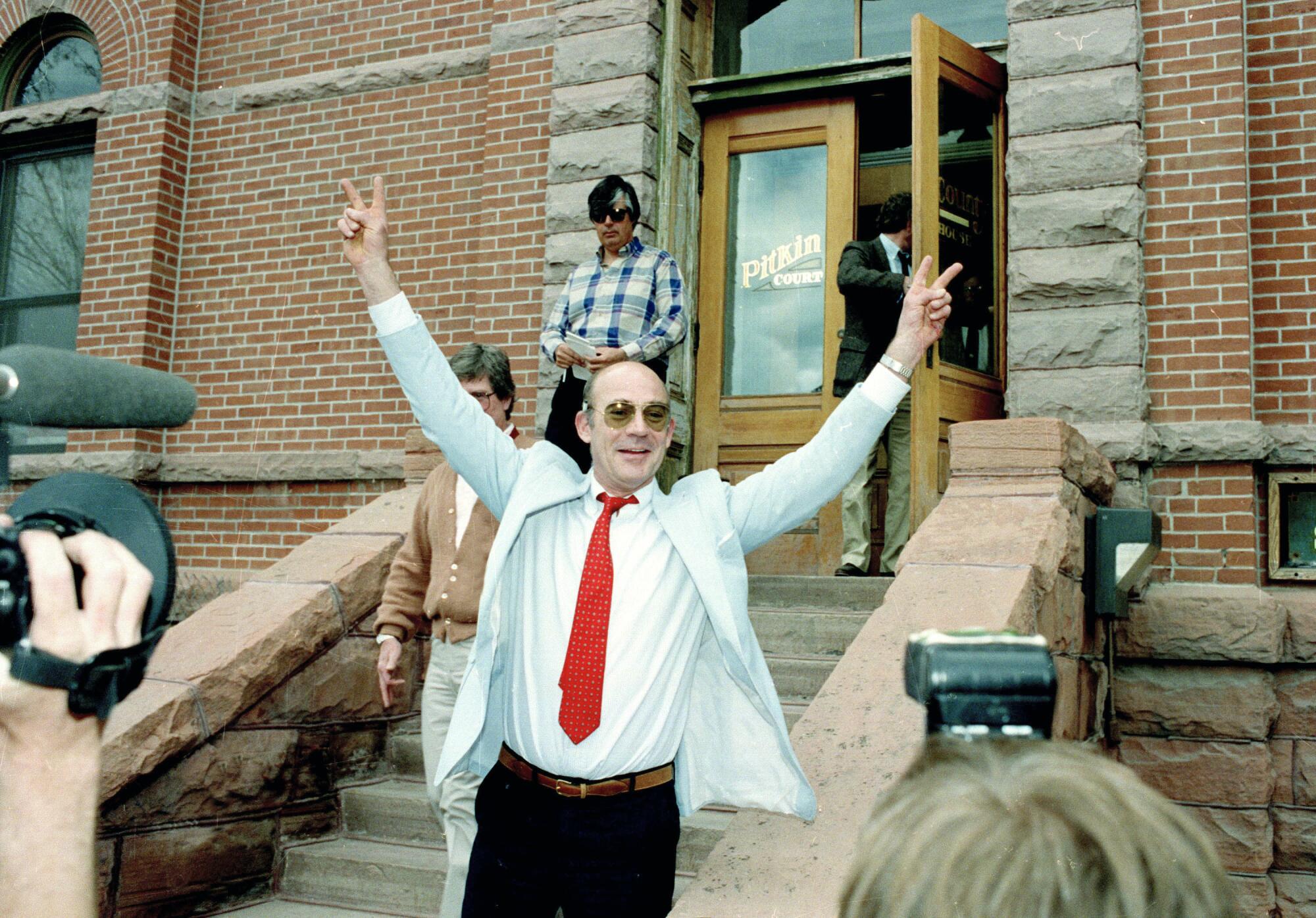 Hunter S. Thompson signals a 'V' for victory sign as he leaves a Colorado courthouse in 1990.  
