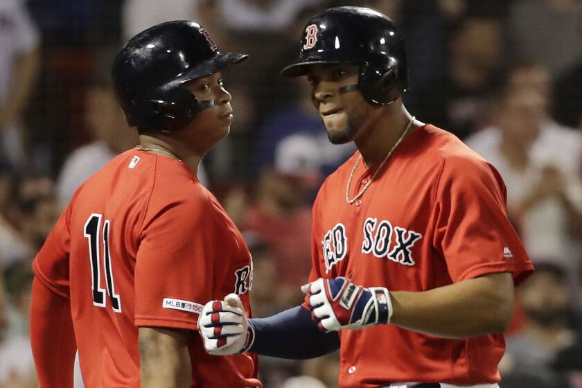 Boston Red Sox's Xander Bogaerts, right, celebrates his three-run home run with Rafael Devers during the seventh inning of the team's baseball game against the Los Angeles Dodgers at Fenway Park, Friday, July 12, 2019, in Boston. (AP Photo/Elise Amendola)
