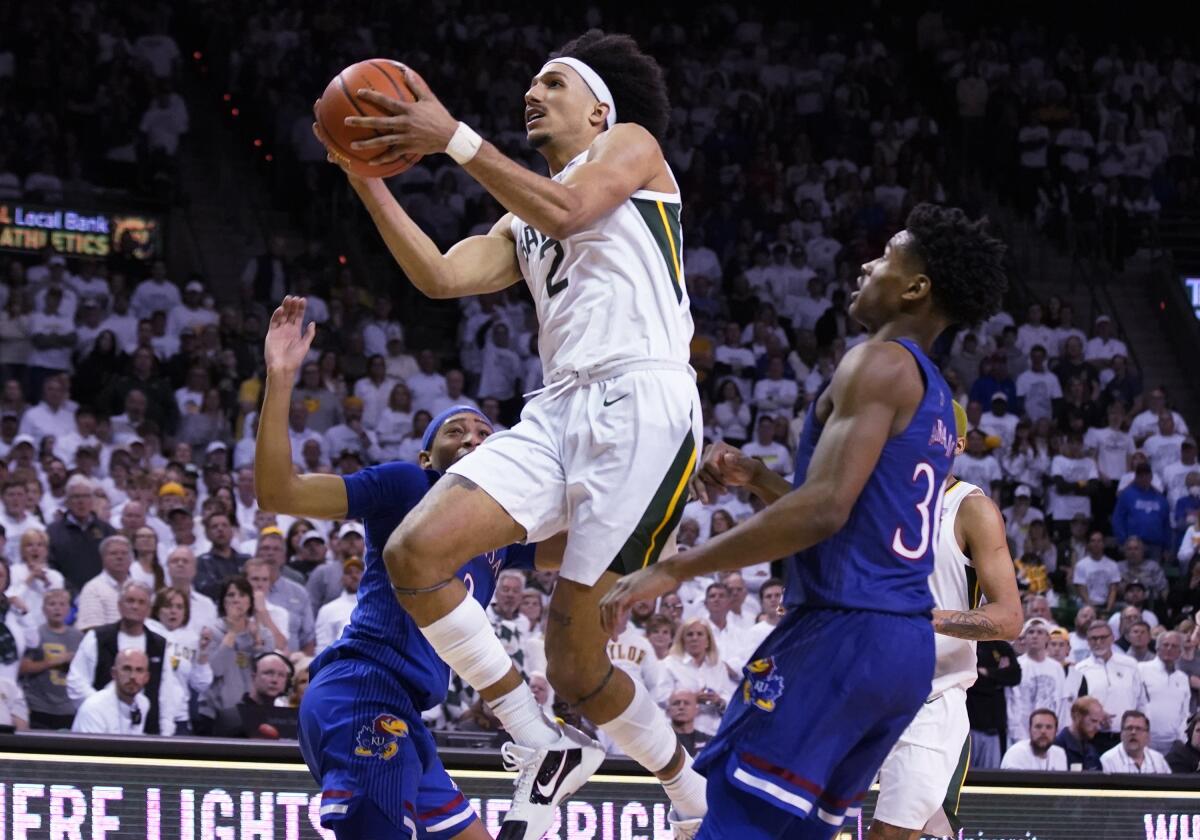 Baylor's Kendall Brown drives past Kansas defenders on his way to the basket Feb. 26, 2022.