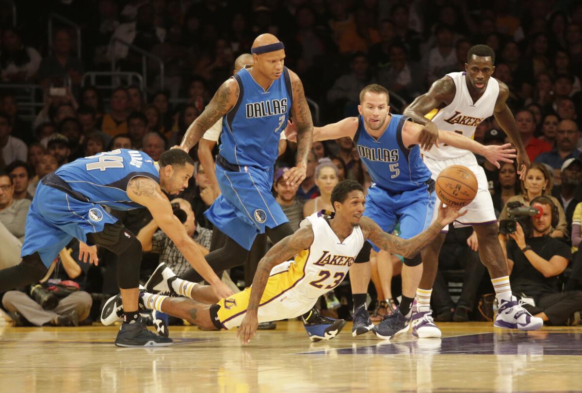 The Lakers' Lou Williams passes under Dallas Mavericks defenders during a game at Staples Center on Nov. 1.