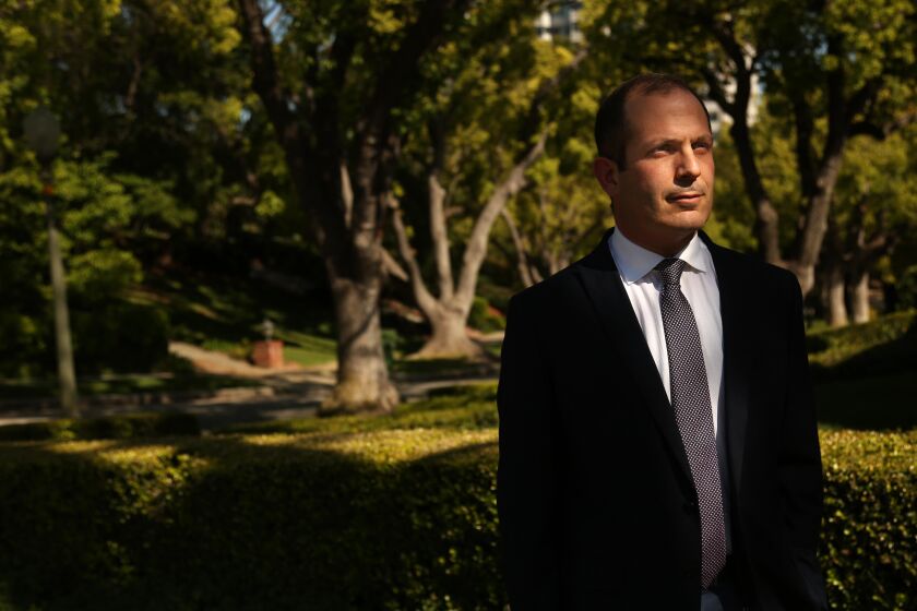 BEVERLY HILLS, CA - APRIL 21, 2020 - - Dr. Nader Pouratian, an associate professor of Neurosurgery Brain Research at UCLA, stands in front of his home in Beverly Hills on Tuesday, April 21, 2020. Dr. Pouratian developed a device that gives a type of artificial sight to blind people and had implanted the device in the brains of four people. The four participants were part of a small clinical trial at UCLA that has been suspended. The pandemic has had an impact on scientific research as universities and other institutions have closed laboratories and suspended many clinical trials. (Genaro Molina / Los Angeles Times)