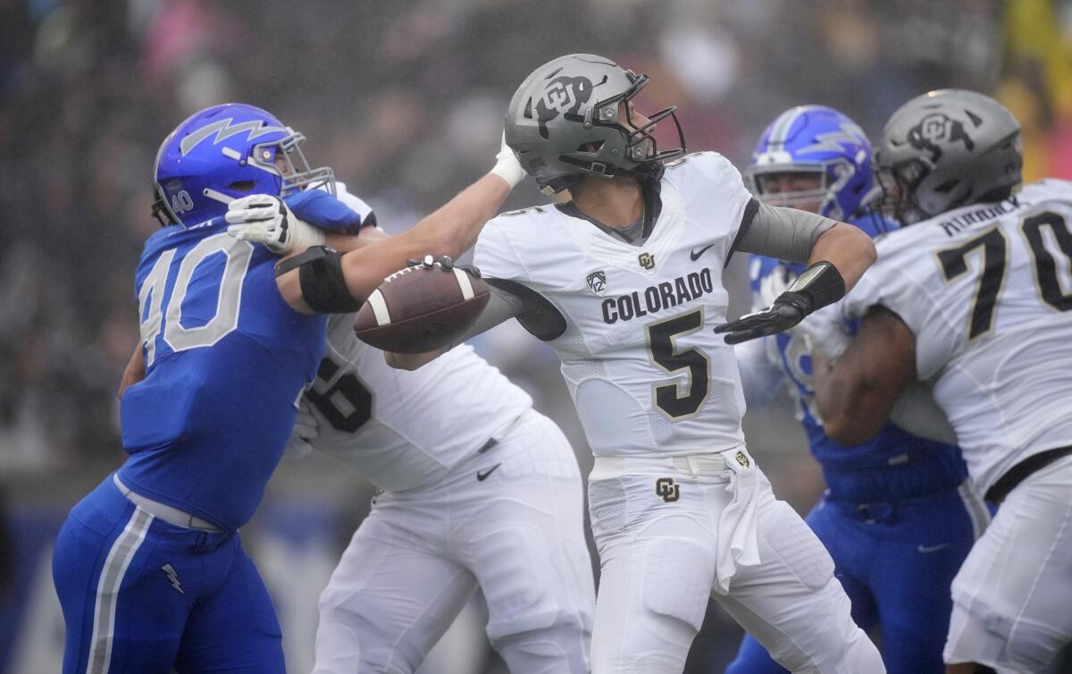 Colorado quarterback J.T. Shrout looks to pass under pressure from Air Force linebacker Alec Mock on Sept. 10, 2022.