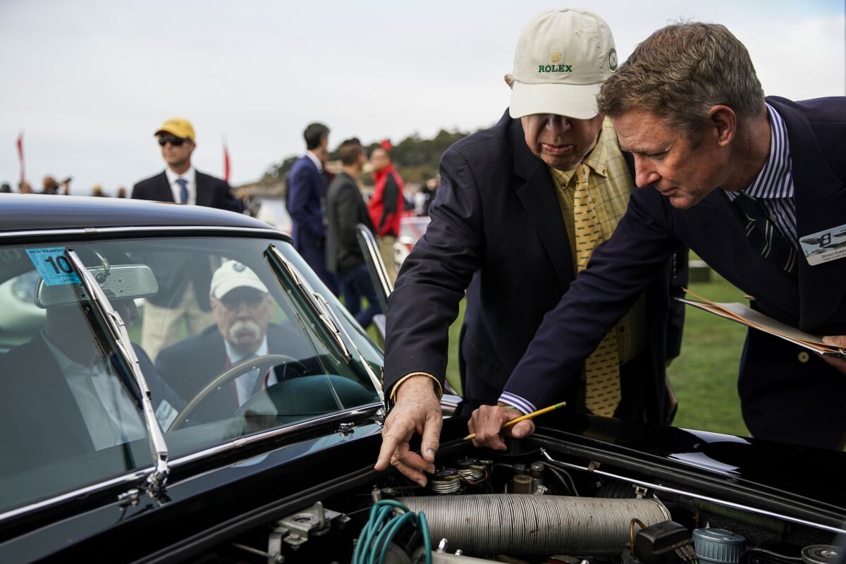 Judge Jerry F. Rosenstock, left, and Chief Class Judge Simon Kidston inspect a 1965 Aston Martin DB5 Vantage coupe at the Concours d'Elegance.