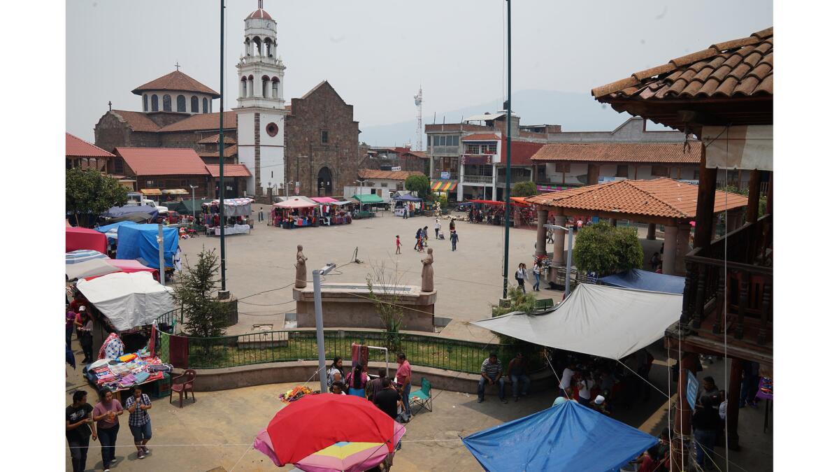 Residents walk through the central plaza of Cheran, Mexico. (Liliana Nieto del Rio / For The Times)