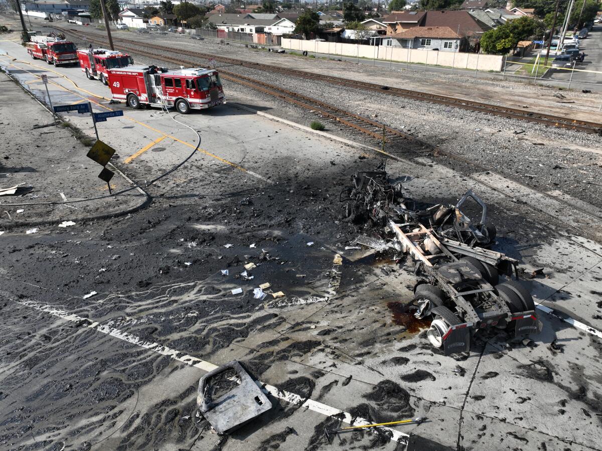An aerial view of a truck explosion, with firefighting equipment visible in the debris.