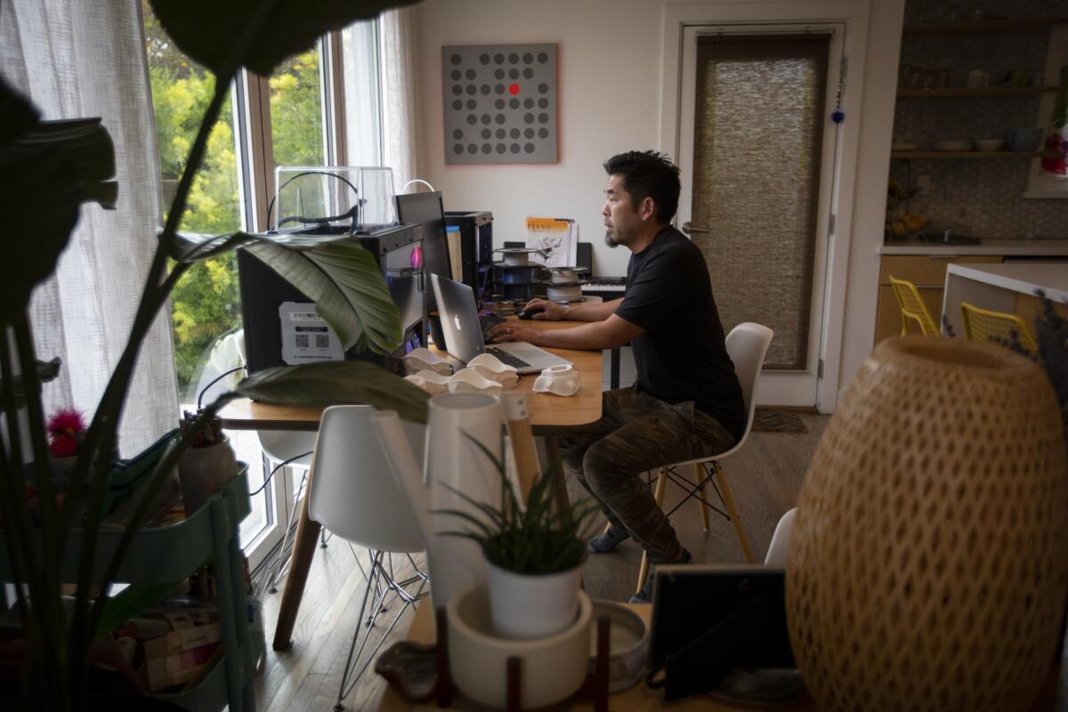 Architect Alvin Huang at his Alhambra home making masks on Monday.