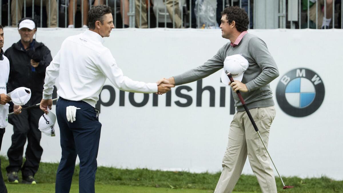 Justin Rose, of England, left, and Keegan Bradley shakes hands after the BMW Championship golf tournament at the Aronimink Golf Club.