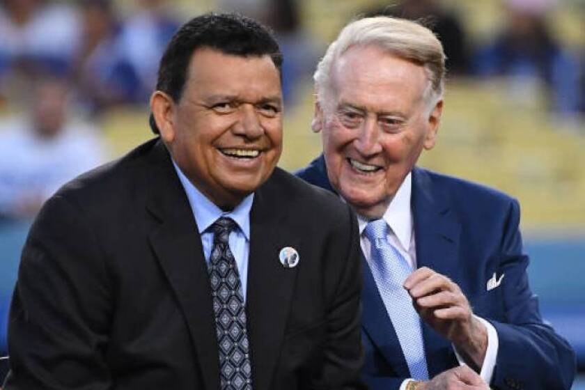 La leyenda de los Dodgers Fernando Valenzuela, a la izquierda, bromea con el retirado locutor del equipo, Vin Scully, durante una ceremonia previa al partido en el Dodger Stadium en septiembre.