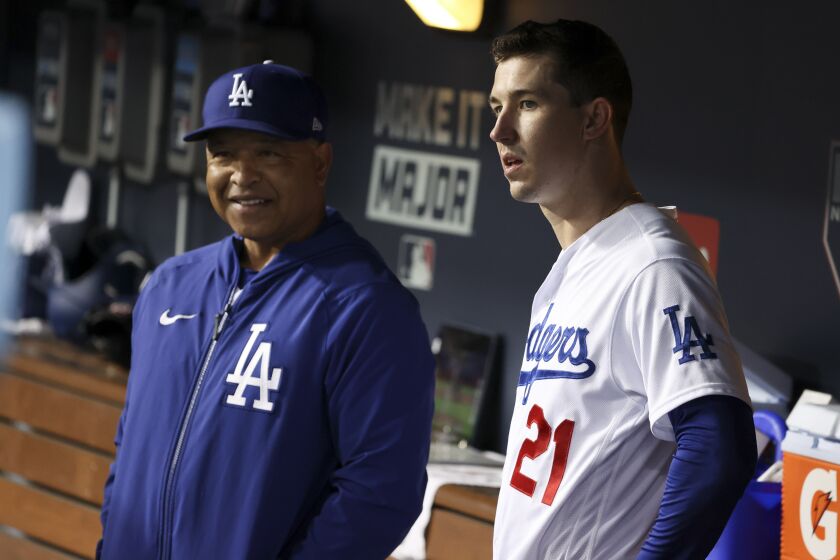 Los Angeles, CA - October 12: Los Angeles Dodgers manager Dave Roberts, left, speaks with Walker Buehler in the dugout during the fifth inning in game four of the 2021 National League Division Series against the San Francisco Giants at Dodger Stadium on Tuesday, Oct. 12, 2021 in Los Angeles, CA. (Robert Gauthier / Los Angeles Times)