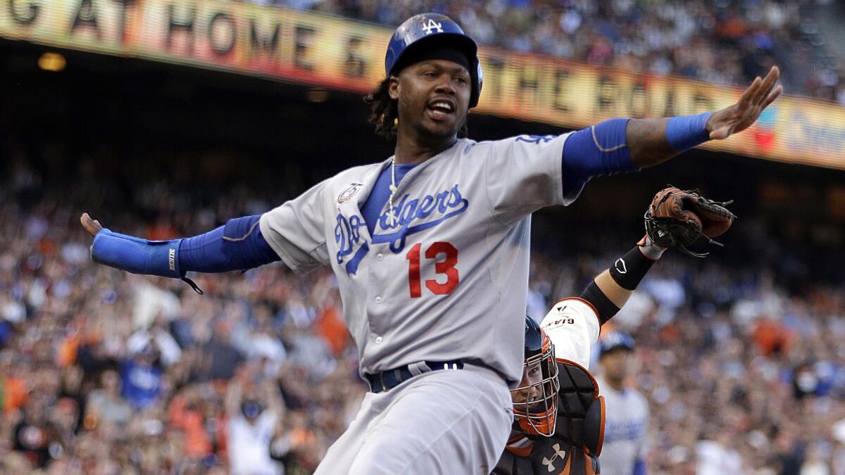 Dodgers shortstop Hanley Ramirez signals he's safe after scoring a run against the San Francisco Giants in July.