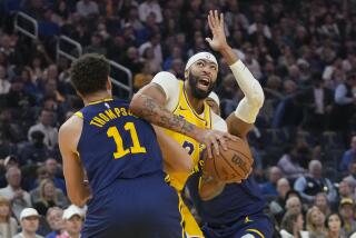 Los Angeles Lakers forward Anthony Davis, middle, is fouled by Golden State Warriors guard Klay Thompson.