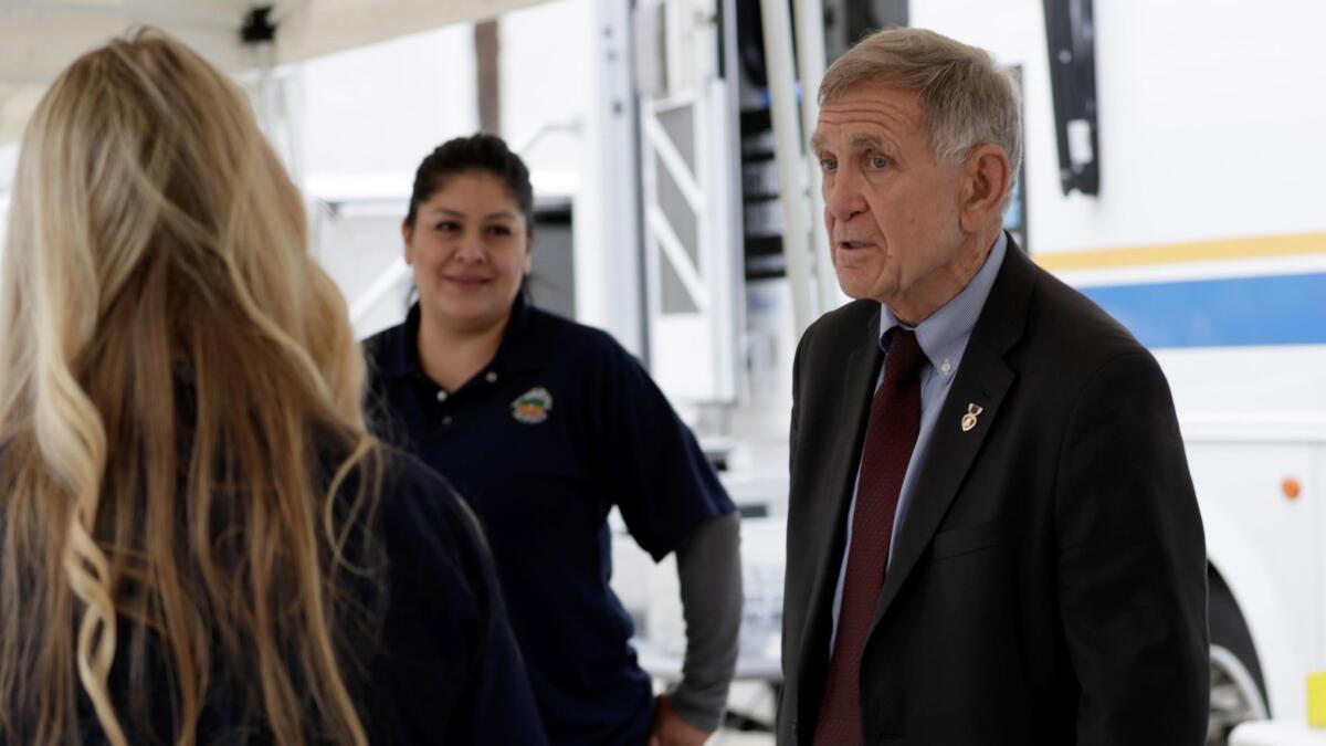U.S. District Judge David Carter visits an Orange County Social Services command post outside the Plaza of the Flags homeless encampment at the Santa Ana Civic Center on Tuesday.