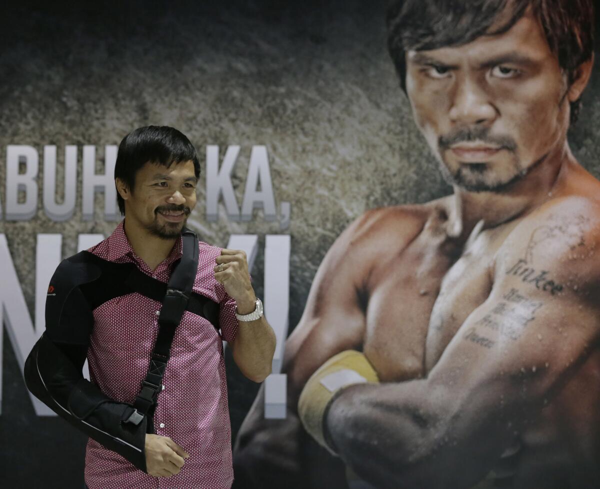 El boxeador filipino Manny Pacquiao posa para fotos tras llegar su país.