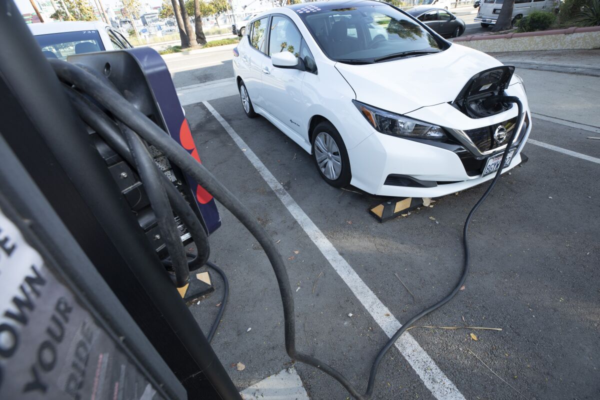 A battery-electric Nissan Leaf is plugged in at a charging station in San Pedro on Dec. 2, 2021. 