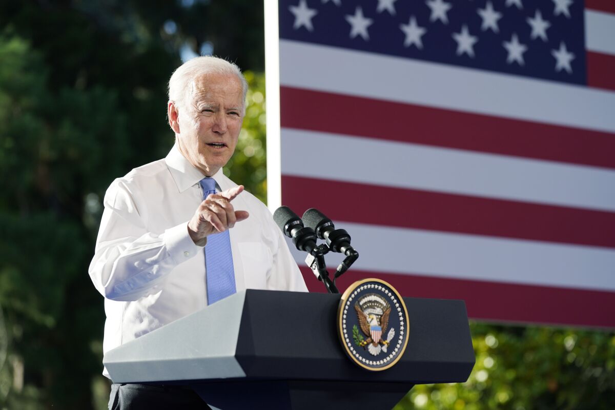 President Biden speaks at a lectern outdoors. 