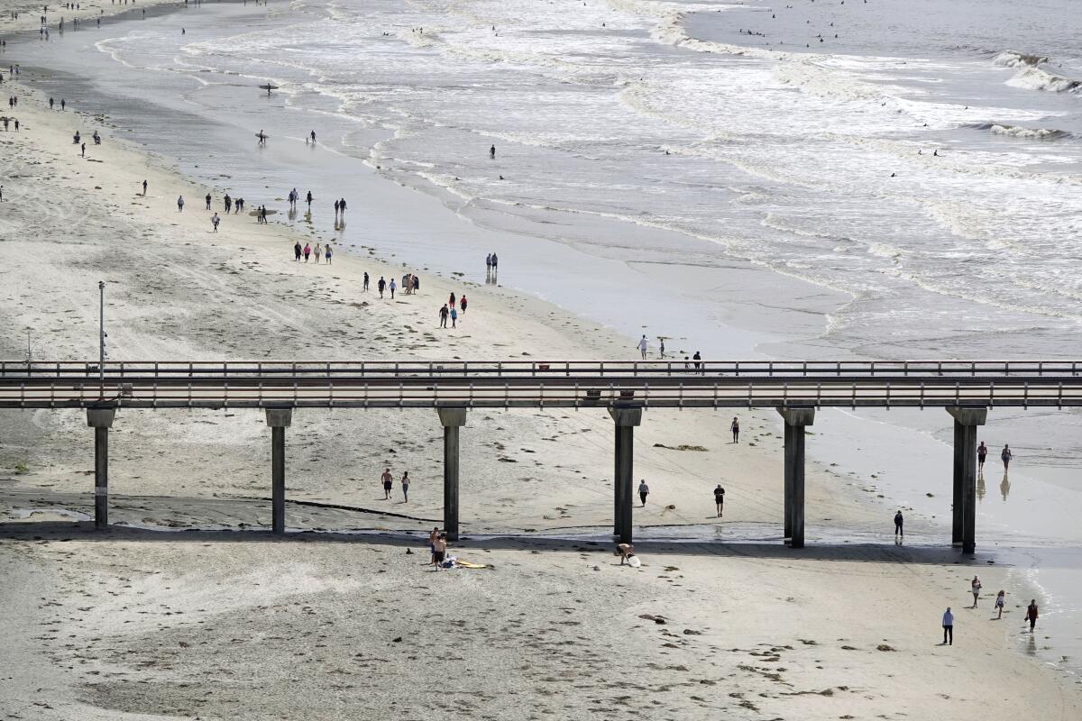 Gov. Gavin Newsom announced that San Diego County beaches would be allowed to remain open. Here people walk along La Jolla Shores on Thursday.