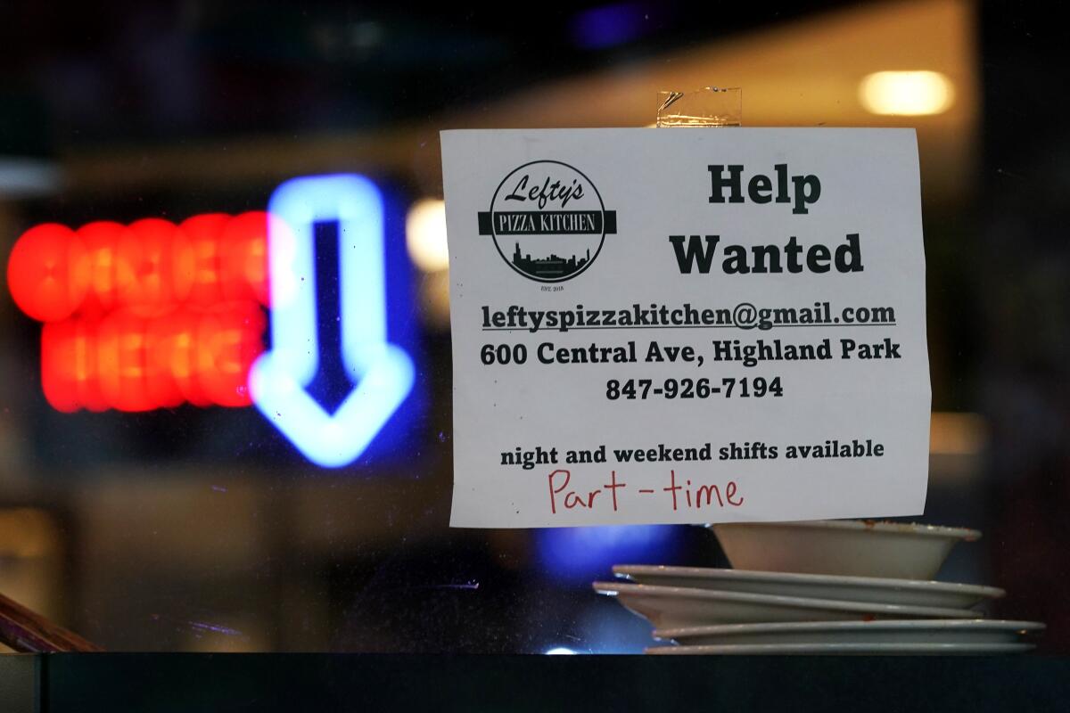 Hiring sign is displayed at a restaurant in Highland Park, Ill.