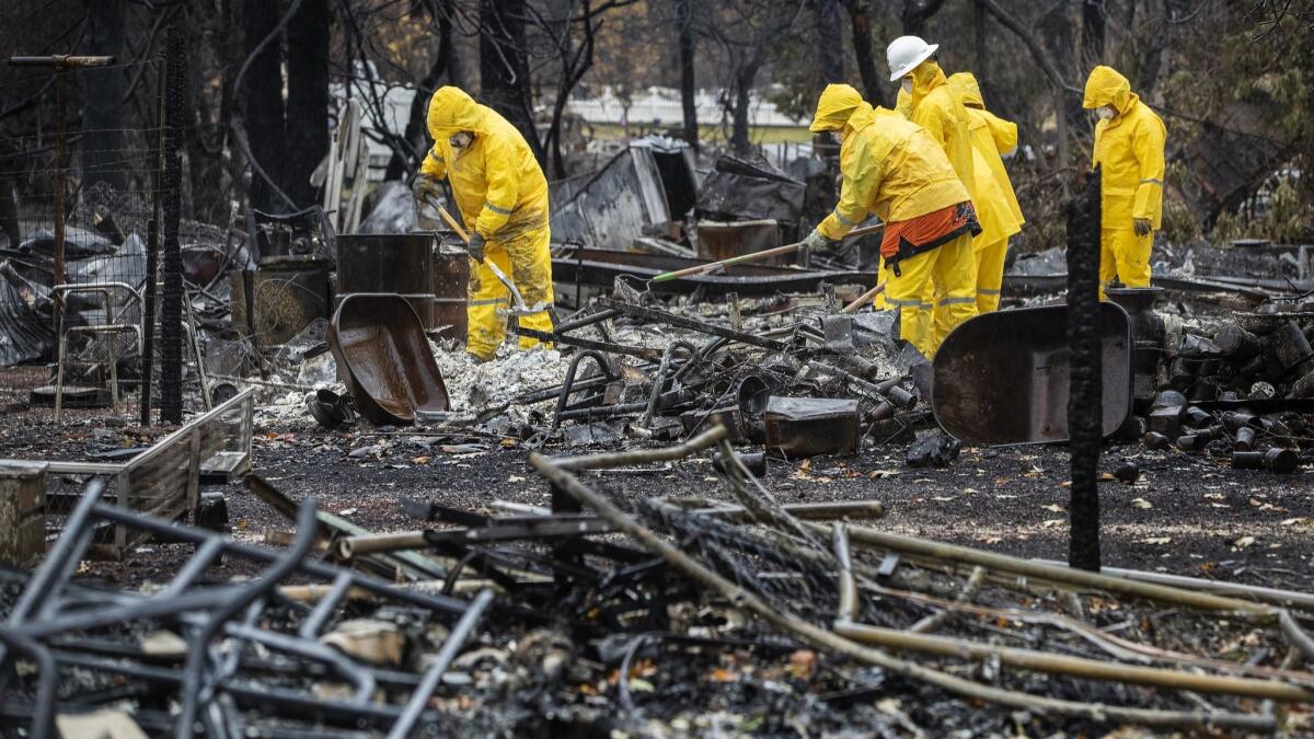 Recovery teams sift through the ashes looking for remains in the debris of a home in Paradise, Calif., during last week's rain.