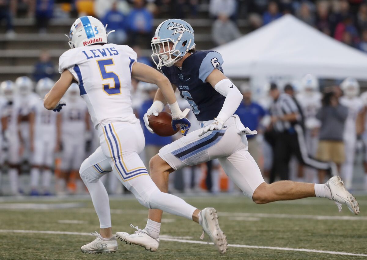 Corona del Mar's John Humphreys, right, gets a first down in the first half against Serra in the CIF State Division 1-A title game on Saturday at Cerritos College.