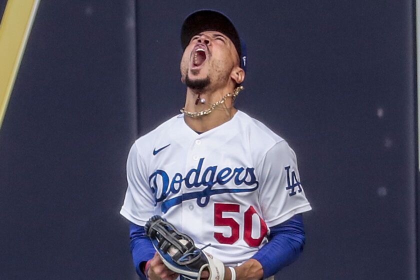 The Dodgers' Mookie Betts celebrates after making a leaping catch.