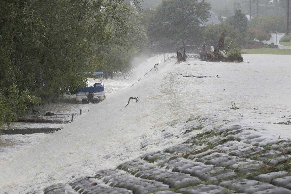 Floodwaters rush over a dam on Forest Lake in Columbia, S.C., on Oct. 4, 2015.