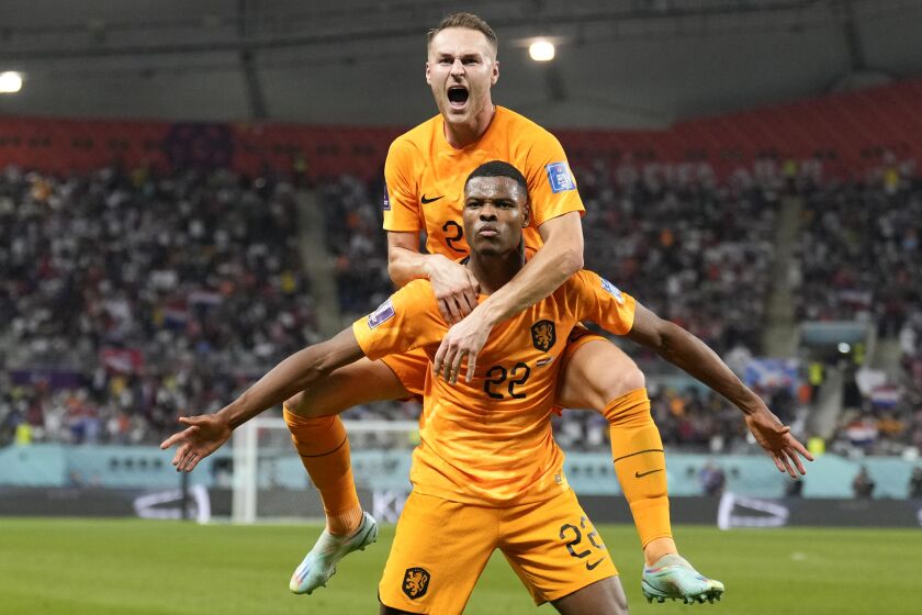 Denzel Dumfries of the Netherlands, bottom, is congratulated after scoring his side's 3rd goal during the World Cup round of 16 soccer match between the Netherlands and the United States, at the Khalifa International Stadium in Doha, Qatar, Saturday, Dec. 3, 2022. (AP Photo/Ashley Landis)