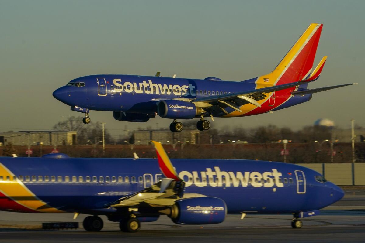 Two Southwest Airlines planes are shown, one in the air and the other on the ground facing the opposite direction.