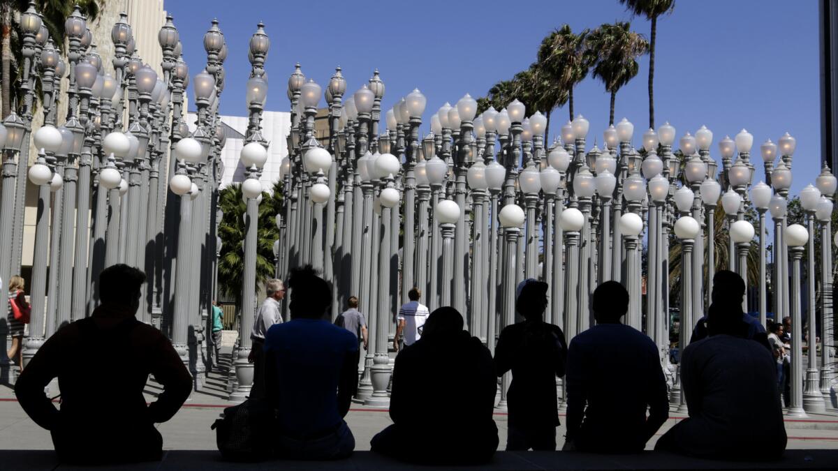 Visitors gather by "Urban Light," the Chris Burden sculpture that has become a symbol of the Los Angeles County Museum of Art.