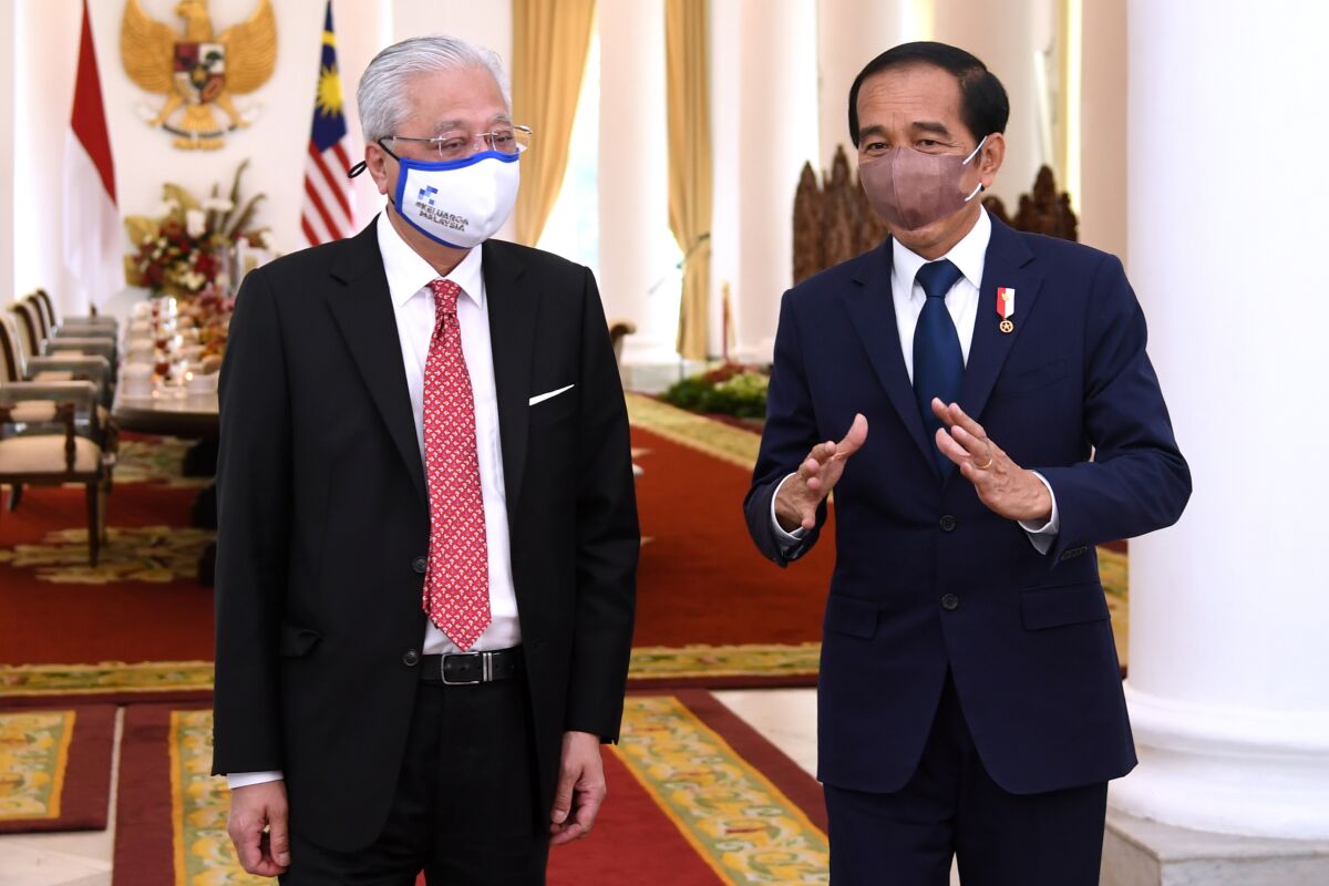 In this photo released by Indonesian Presidential Palace, Indonesian President Joko Widodo, right, gestures as he speaks to Malaysian Prime Minister Ismail Sabri Yaakob during their meeting in Bogor, West Java, Indonesia, Wednesday, Nov. 10, 2021. The leaders of Malaysia and Indonesia on Wednesday urged military-ruled Myanmar to resolve its internal conflict and help stem the flow of Rohingya refugees fleeing to Malaysia. (Indonesian Presidential Palace via AP)