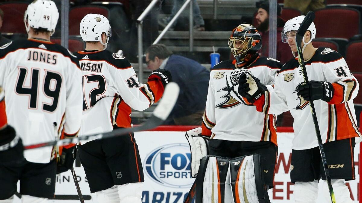 Ducks goaltender Ryan Miller, second from right, celebrates the team's 3-1 win against the Arizona Coyotes with teammates as time expires on Tuesday in Glendale, Ariz.