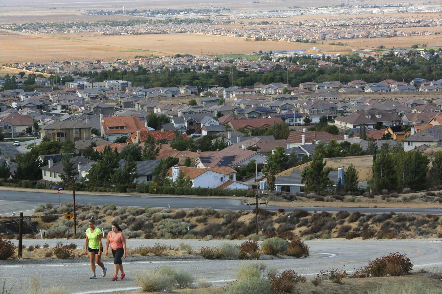 Penny Munz, left, walks with her daughter Stephanie in Palmdale; Lancaster is in the distance. The rift between the two towns has baffled residents, city employees and business interests.