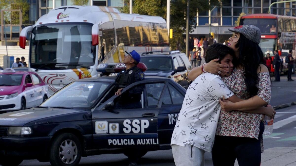 A woman embraces a boy as a powerful earthquake rocked Mexico City on Friday.