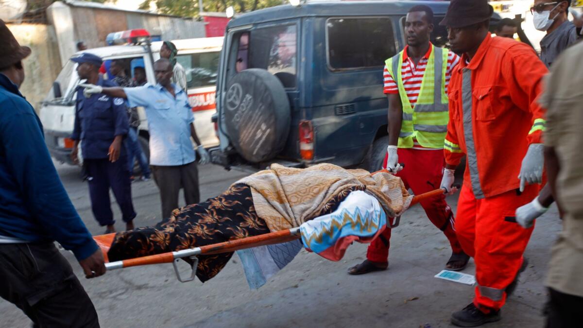 Crews carry a body after an explosion and siege at a Mogadishu hotel.