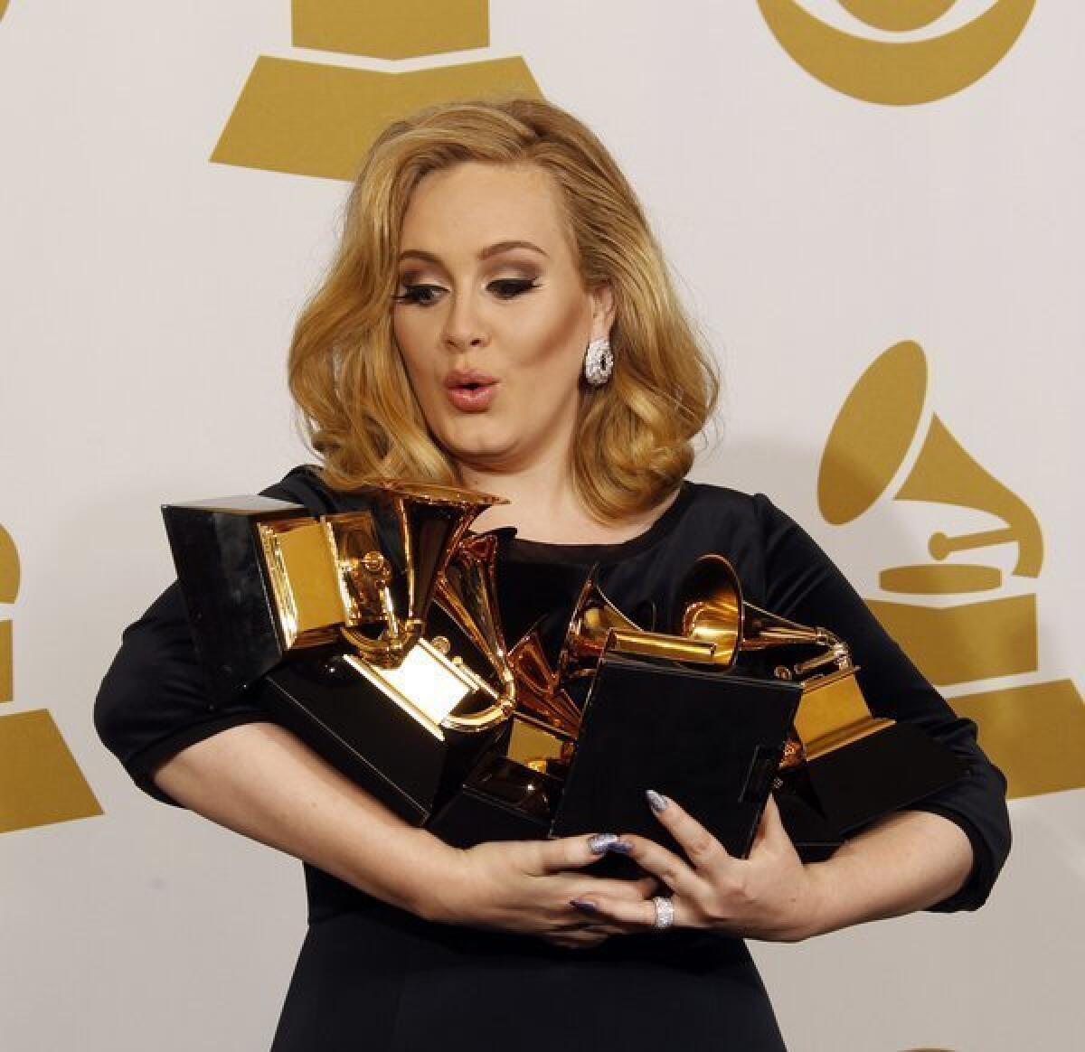 Adele holds her awards at the 54th Annual Grammys in 2012. This milestone and others won't be turning up in an autobiography.