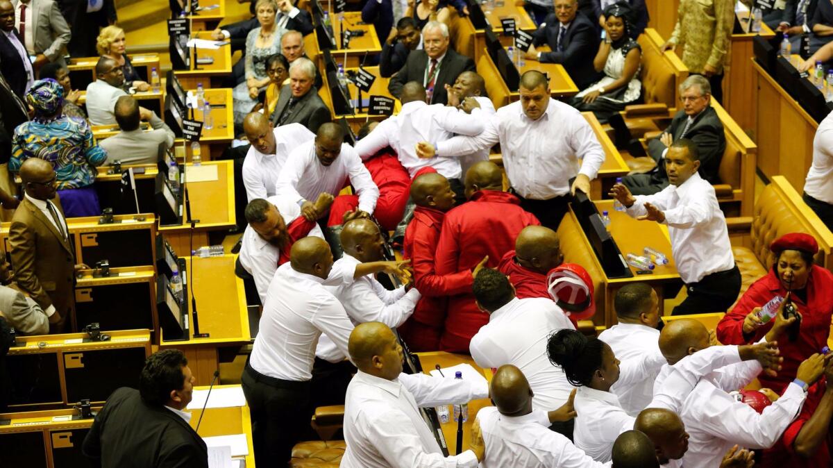 Security officials force out South African opposition party Economic Freedom Fighters (EFF) members during the South African president's speech for the 2017's State Of the Nation Address on Thursday.