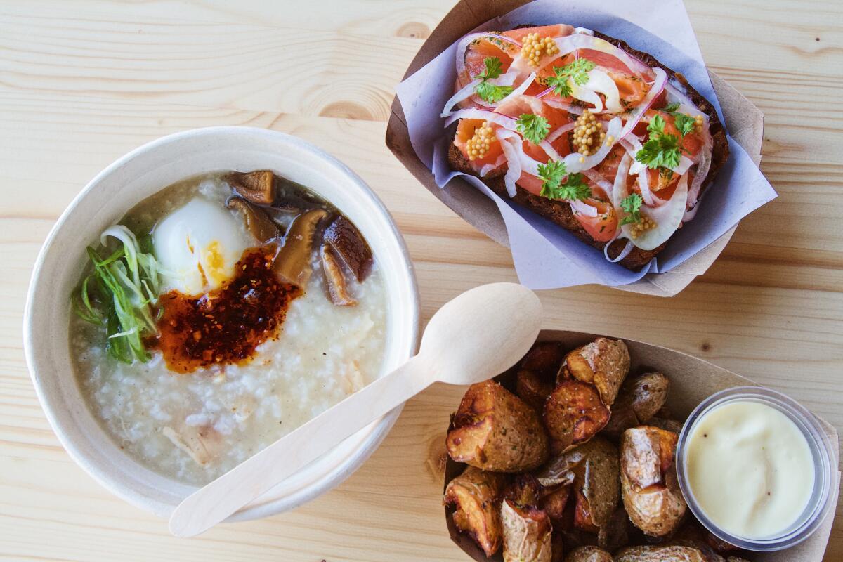 An overhead of three dishes from Little Fish at Echo Park's Dada Market: fish congee, potatoes, and cured-trout tartine