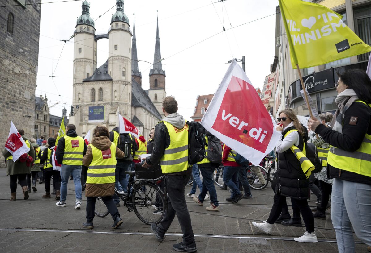 Demonstrators march through downtown Halle/Saale, Germany, Thursday, March 23, 2023. German unions are calling on thousands of workers across the country's transport system to stage a one-day strike on Monday that is expected to bring widespread disruption to planes, trains and local transit. (Hendrik Schmidt/dpa/dpa via AP)