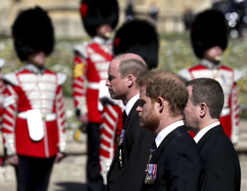 Prince William and Prince Harry walk with relatives past guards 