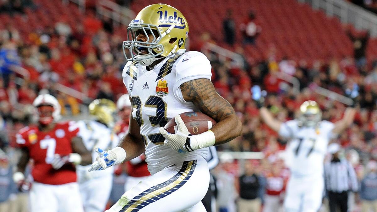 Bruins running back Nate Starks breaks into the clear on a 26-yard scoring pass play against Nebraska in the Foster Farms Bowl last season.